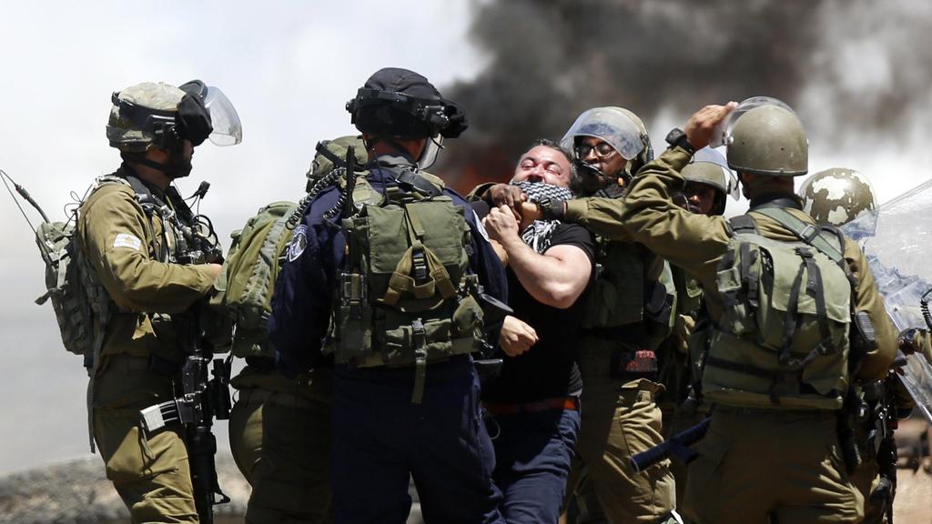 Israeli soldiers forcing Palestinians out