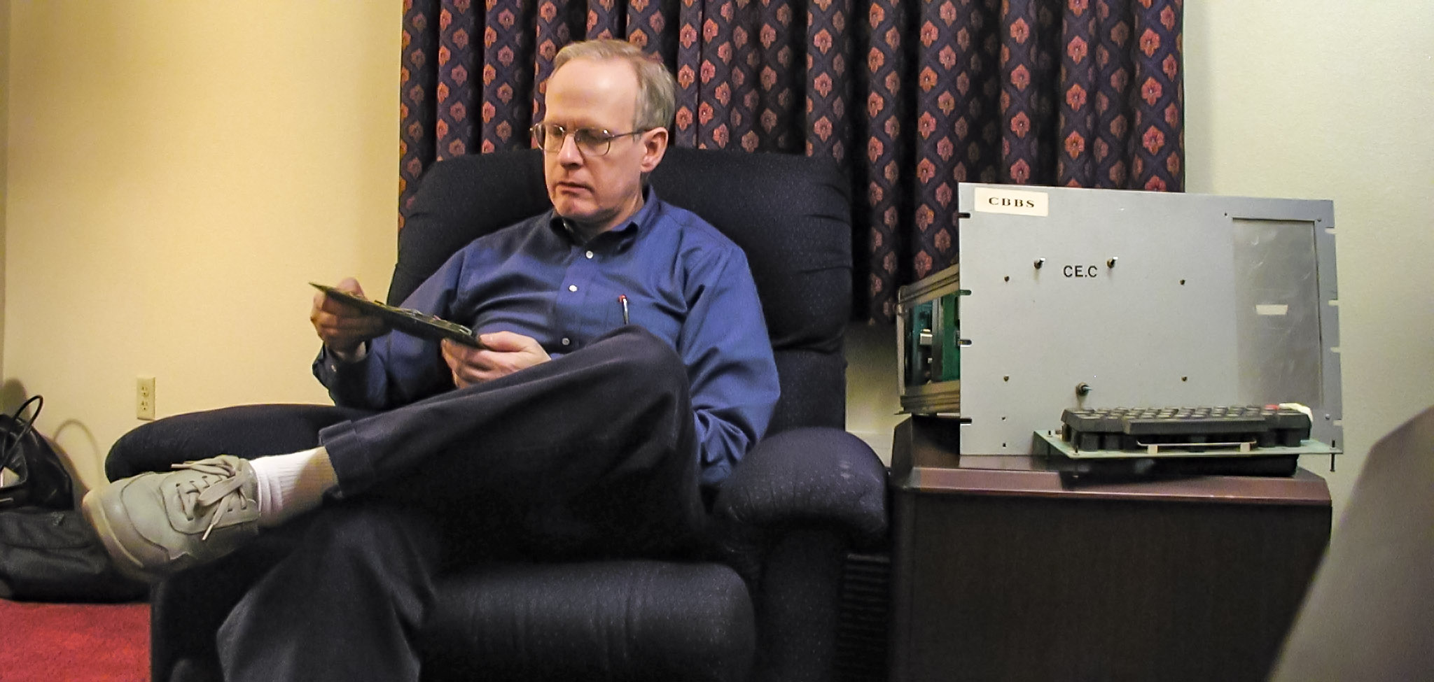 Ward Christensen holds an expansion card from the original CBBS S-100 host machine.